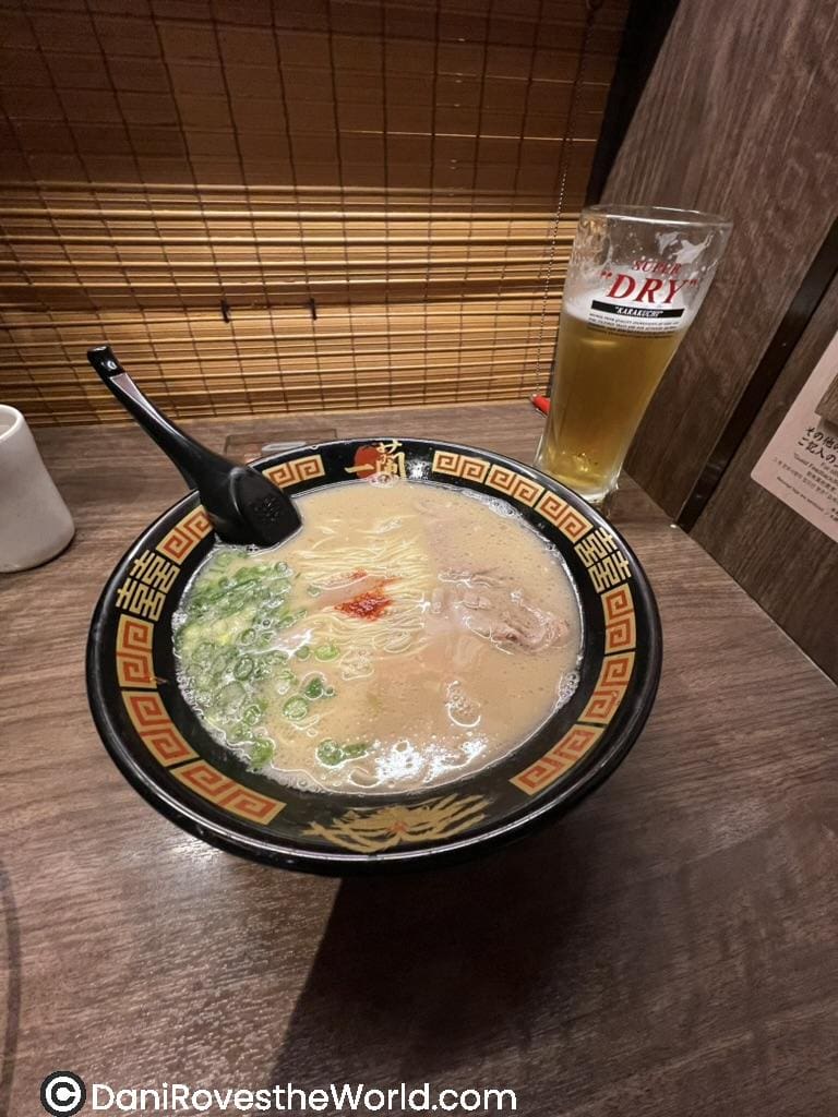 Bowl of rich ramen with green onions and a slice of pork, served alongside a glass of beer at Ichiran Ramen in Tokyo. A delicious stop for authentic Japanese cuisine, perfect for a food-focused experience during a 1 week Tokyo itinerary.
