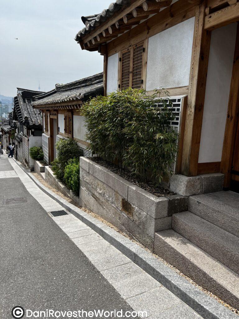 A quiet street in Bukchon Hanok Village, lined with traditional Korean houses and bamboo plants. Tips for visiting Seoul: Explore Bukchon Hanok Village for a scenic stroll through Seoul’s rich history and culture.