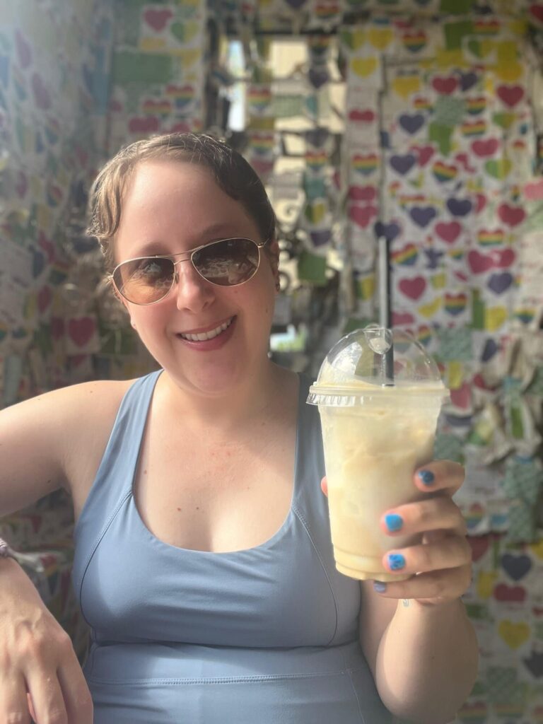 Dani in Hanoi Vietnam holding an iced coconut coffee from the famous Note Cafe
