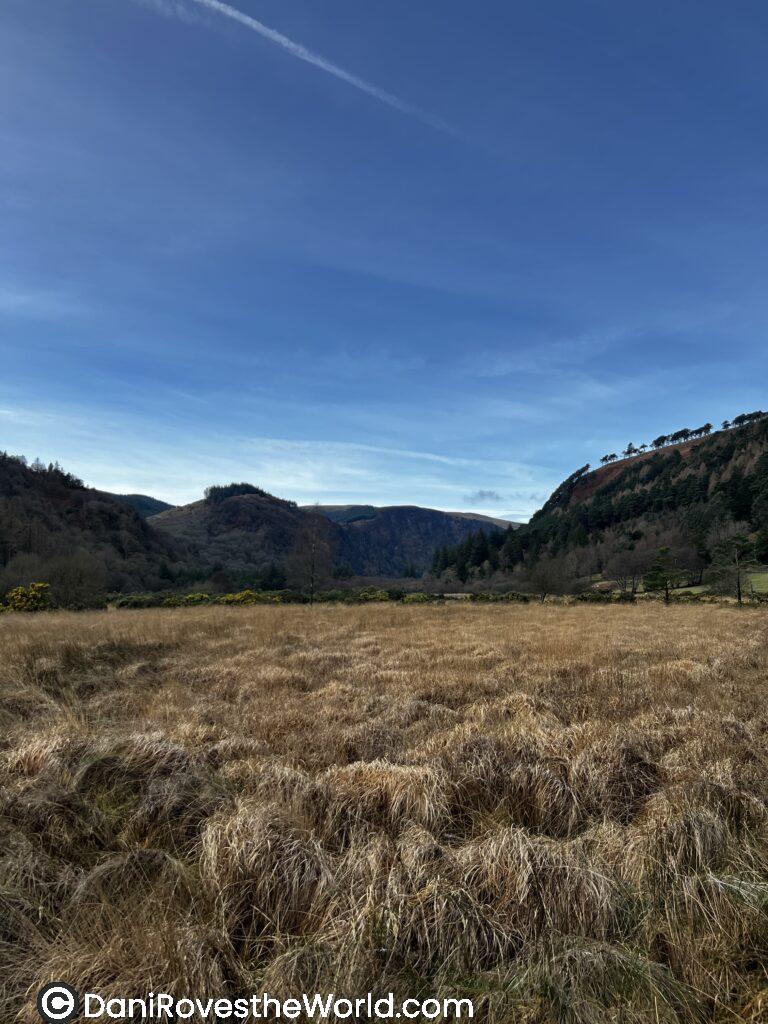 A peaceful meadow in Wicklow, Ireland surrounded by mountains, showcasing the natural beauty, safety, and tranquility that are key factors contributing to a country being a good place for solo female travelers.
