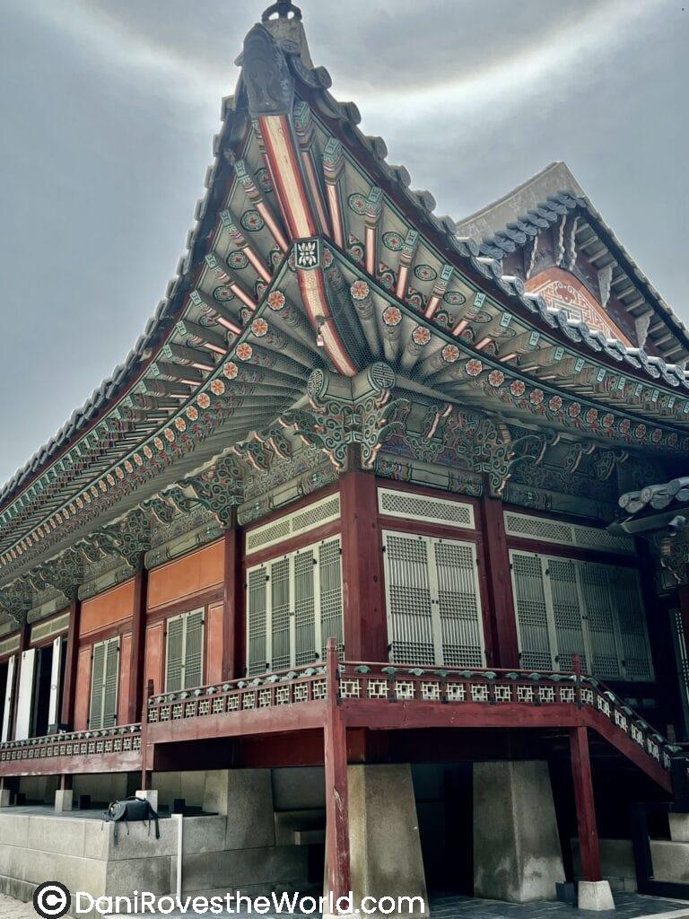 A majestic view of Gyeongbokgung Palace, showcasing its grand architecture with ornate rooftops and vibrant detailing, set against a clear blue sky