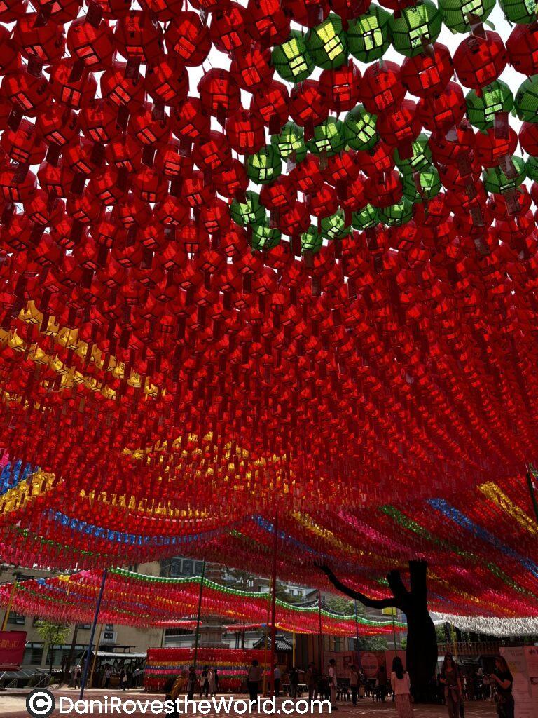 A dense array of red and green lanterns hanging overhead in a Seoul temple, part of festive preparations. Spring festivals like Buddha's Birthday often feature such decorations, marking it as one of the best times to visit Seoul for cultural experiences.