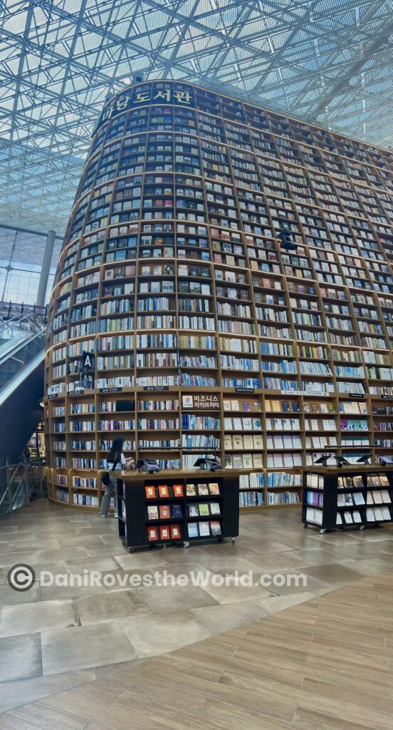 Towering bookshelf filled with books at the Starfield Library in COEX Mall, Gangnam, offering a visually impressive and cultural experience for visitor