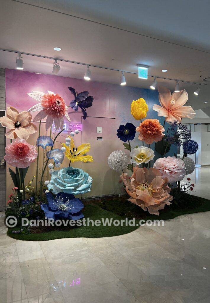 Oversized artificial flower display in a Gangnam shopping mall, showcasing the district's modern, artistic, and vibrant atmosphere.