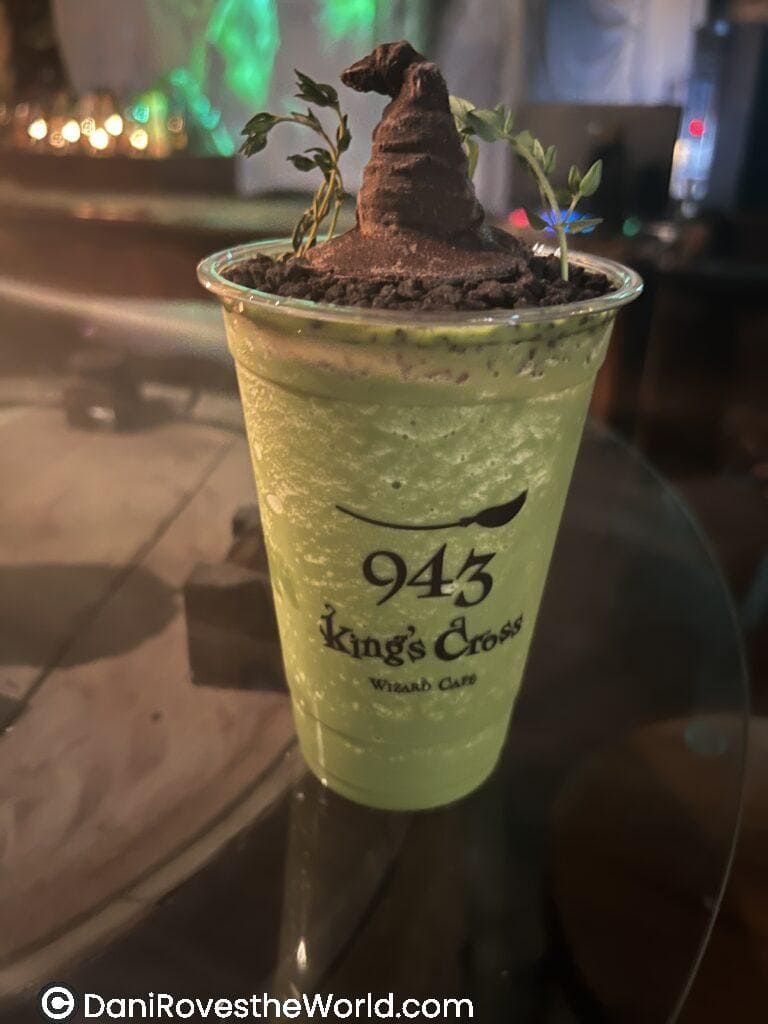 A themed green drink topped with a chocolate Sorting Hat, served at 943 King's Cross Wizard Cafe in Seoul, part of the immersive Harry Potter themed experience