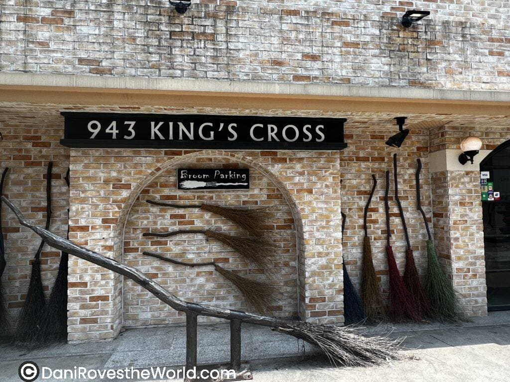 The broom parking area at 943 King's Cross, a Harry Potter-themed cafe in Seoul, featuring broomsticks and a brick entrance that welcomes fans of the magical world. Harry Potter Cafe Seoul