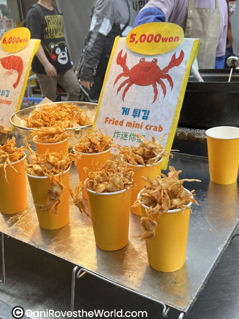 Fried mini crabs served in cups at myeongdong night market, a unique and crispy snack that is a must try food for anyone exploring the city's vibrant street food scene