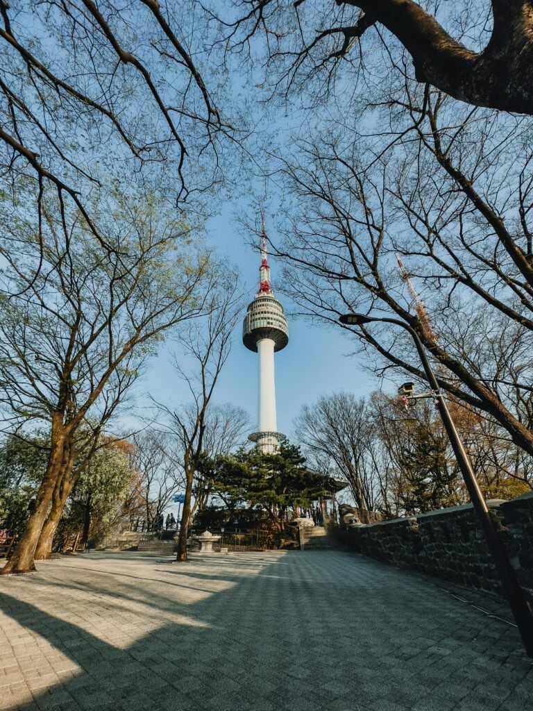 A panoramic view of Seoul from above, featuring a mix of modern skyscrapers and distant mountains. Experience the historical transformation of the city from its ancient roots to modern times during 24 hours of history in Seoul.