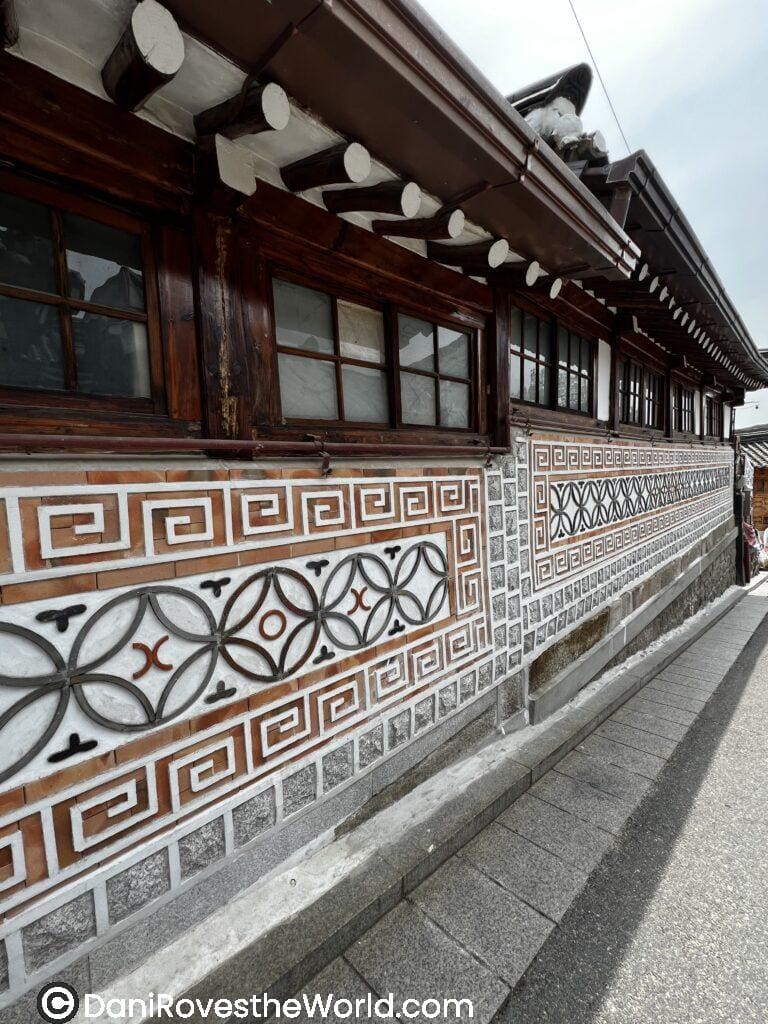 Close-up of a traditional Korean house in Bukchon Hanok Village, featuring intricate wall designs with geometric patterns.