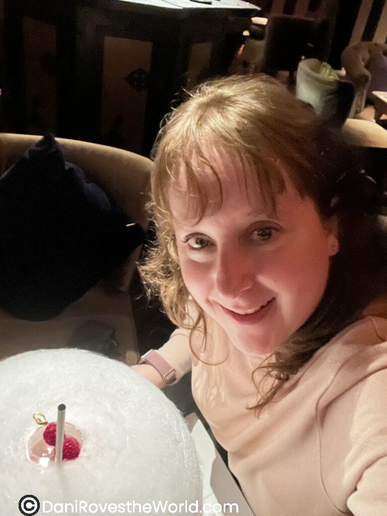 Woman with a cocktail topped with cotton candy and berries in Tokyo