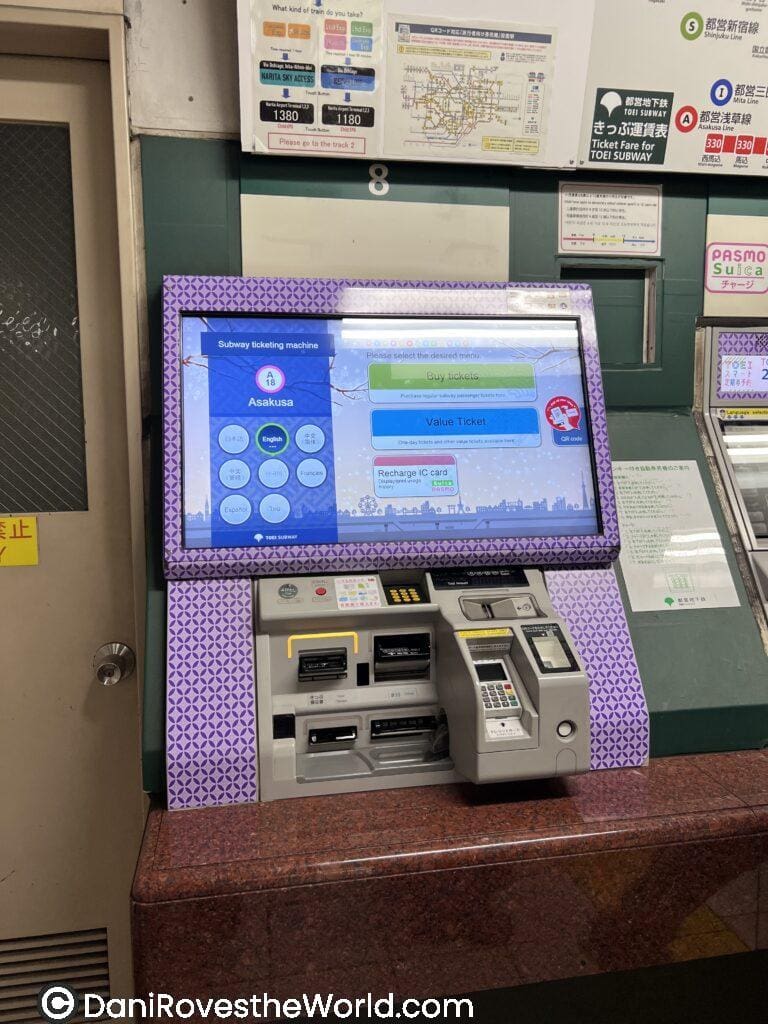 A multilingual Tokyo subway ticket machine at Asakusa Station displays options to buy tickets or recharge IC cards like Suica or Pasmo. The touchscreen interface offers language selection and payment slots for cash or card, helping travelers navigate Tokyo’s transit system easily.