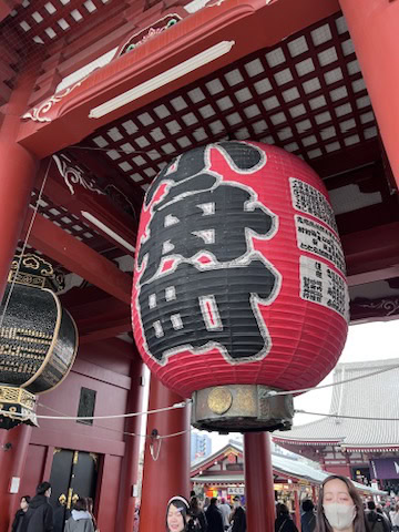 Iconic red lantern hanging at the Kaminarimon Gate entrance of Senso-ji Temple, surrounded by visitors and vibrant energy. A classic photo spot when exploring Asakusa.